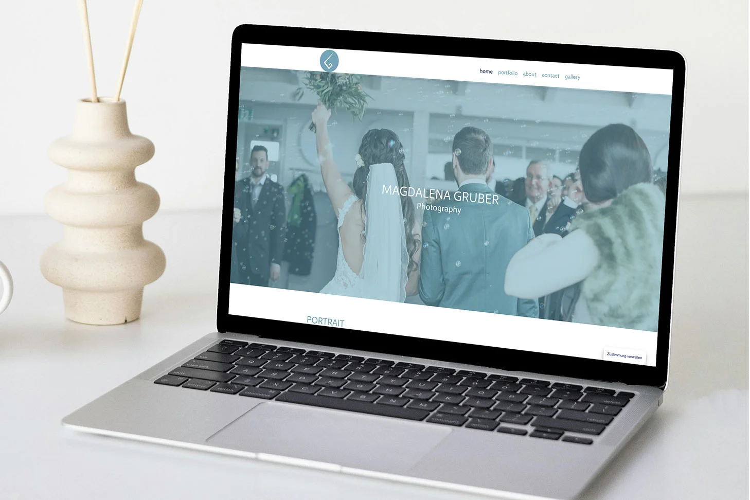 Webseite von Fotografin auf Laptop dargestellt mit Vase im Hintergrund.
